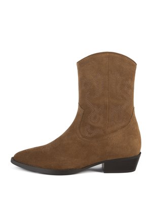 Stivale alla caviglia in suede marrone con punta affusolata, cuciture decorative e tacco basso a blocco. Texture liscia, altezza fino al polpaccio e senza hardware visibile.