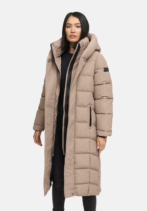 Manteau rembourré long beige avec une grande capuche, fermeture éclair et texture matelassée ; il possède des poches latérales et un écusson logo sur la manche.