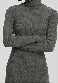 Vestito a tubo a collo alto in tessuto a costine di colore grigio scuro. Maniche lunghe con aperture per il pollice. Texture morbida, design aderente, lunghezza fino al ginocchio. Senza motivi visibili.
