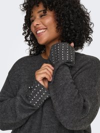 Gray knitted sweater with a loose fit, featuring textured ribbed cuffs adorned with small, shiny beads.