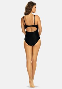 Czarny jednoczęściowy kostium kąpielowy z regulowanymi ramiączkami, otwartym tyłem i gładką teksturą. Posiada bezszwowy design i minimalne zakrycie.