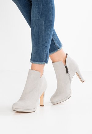 Lysegrå ruskindshøje hæle ankelstøvler med sidelommer, båret med cropped blå jeans med frynset kant.