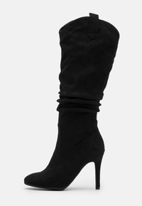 Czarne zamszowe botki kozaki z końcówką w szpic i obcasem w stylu stiletto. Posiadają marszczoną cholewkę oraz tylną pętlę, która ułatwia zakładanie.