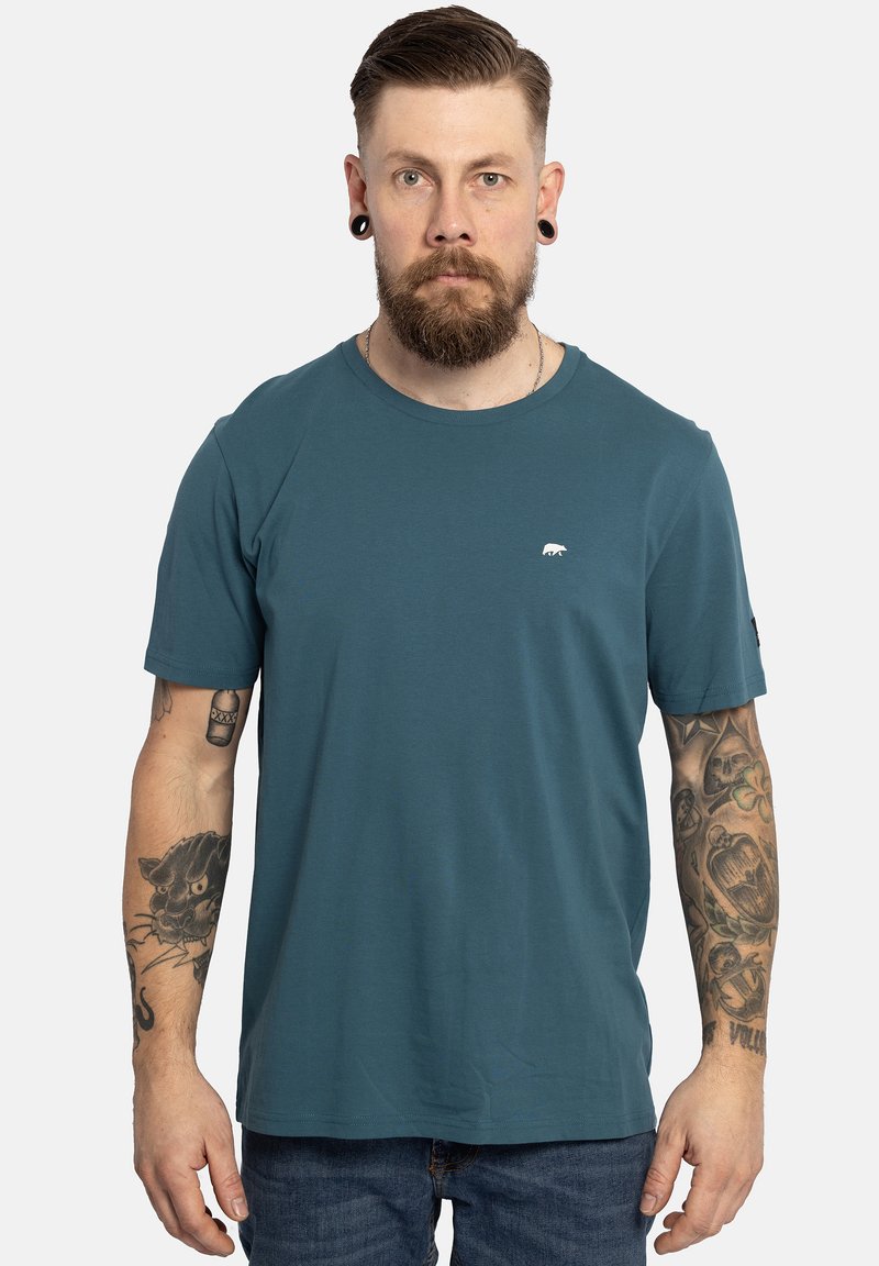 Teal crew neck t-shirt gemaakt van zachte stof, met een klein wit berenlogo op de borst en korte mouwen. Eenvoudig ontwerp, losse pasvorm.