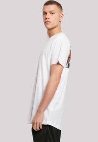 White cotton t-shirt with a crew neck, short sleeves, and a colorful graphic on the back featuring intricate designs and patterns.