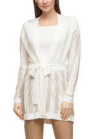 Biały kardigan z paskiem, z szerokimi rękawami i paskami przezroczystego materiału. Miękka tekstura; zaprojektowany w stylu z otwartym przodem.