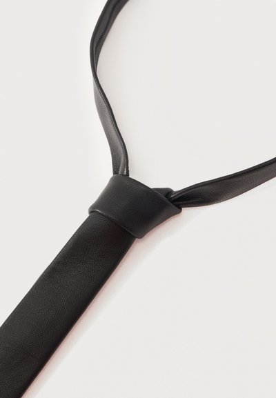 Cravate en cuir synthétique noir avec un nœud simple sur un fond clair, mettant en valeur sa texture lisse et son design élégant.