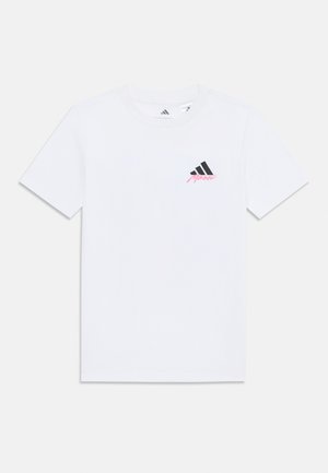 T-shirt bianco in cotone con colletto rotondo, maniche corte, caratterizzato da un logo Adidas nero e un accento di testo rosa sul petto.