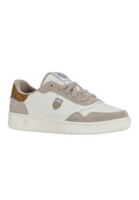 Baskets en cuir blanc avec des accents en daim beige clair, une semelle texturée et un détail distinctif au talon brun tacheté. Présente un design cousu et un système de laçage.