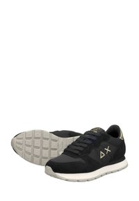 Zapatillas deportivas negras hechas de ante y malla, con una suela blanca, detalles en dorado y un diseño de cordones con logotipo.