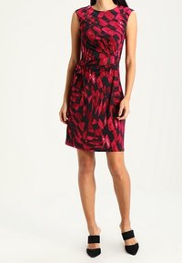 Lyhythihainen, polvipituinen mekko tummanpunaisessa ja mustassa geometrisessa kuosissa. Valmistettu sileästä kankaasta, jossa on muotoiltu vyötärö ja sivuontelo.