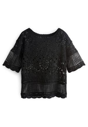 Blouse courte à manches courtes en dentelle crochet noire avec des motifs floraux et en grille, bords festonnés et encolure ronde.