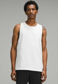 Hvid ærmeløs tanktop lavet af blødt bomuldsstof. Har en rund hals og normal pasform. Let tekstur, simpelt design uden mønstre.