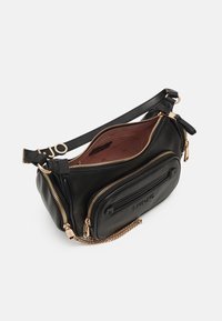 Bolso de piel negra tipo bandolera con herrajes en tono dorado, múltiples compartimentos con cremallera y un acento de cadena en la correa. El interior cuenta con un forro estampado.