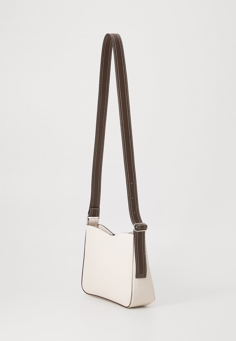 Bolso de hombro de piel blanca con forma estructurada, correa marrón con costuras blancas y un ligero arco en el borde superior.