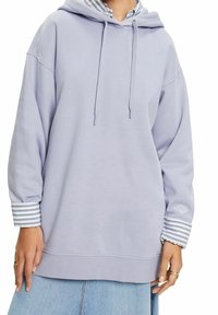 Sudadera de lavanda jaspeada con capucha ajustable, dobladillo acanalado y detalles de puños a rayas. Tejido suave con un corte relajado.