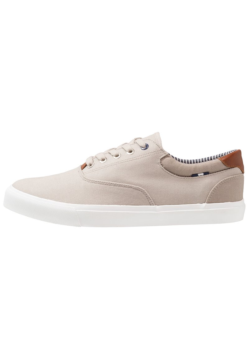 Beige canvas sneakers med vit gummisula, rund tå och snörning. Brunt läderdetalj på hälen, randig innersula.