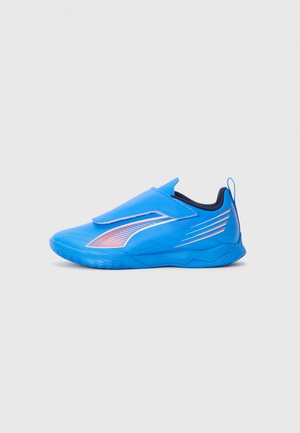 Chaussure de sport bleue avec un dessus synthétique lisse, une sangle élastique, des détails texturés et des accents orange contrastants sur le côté.
