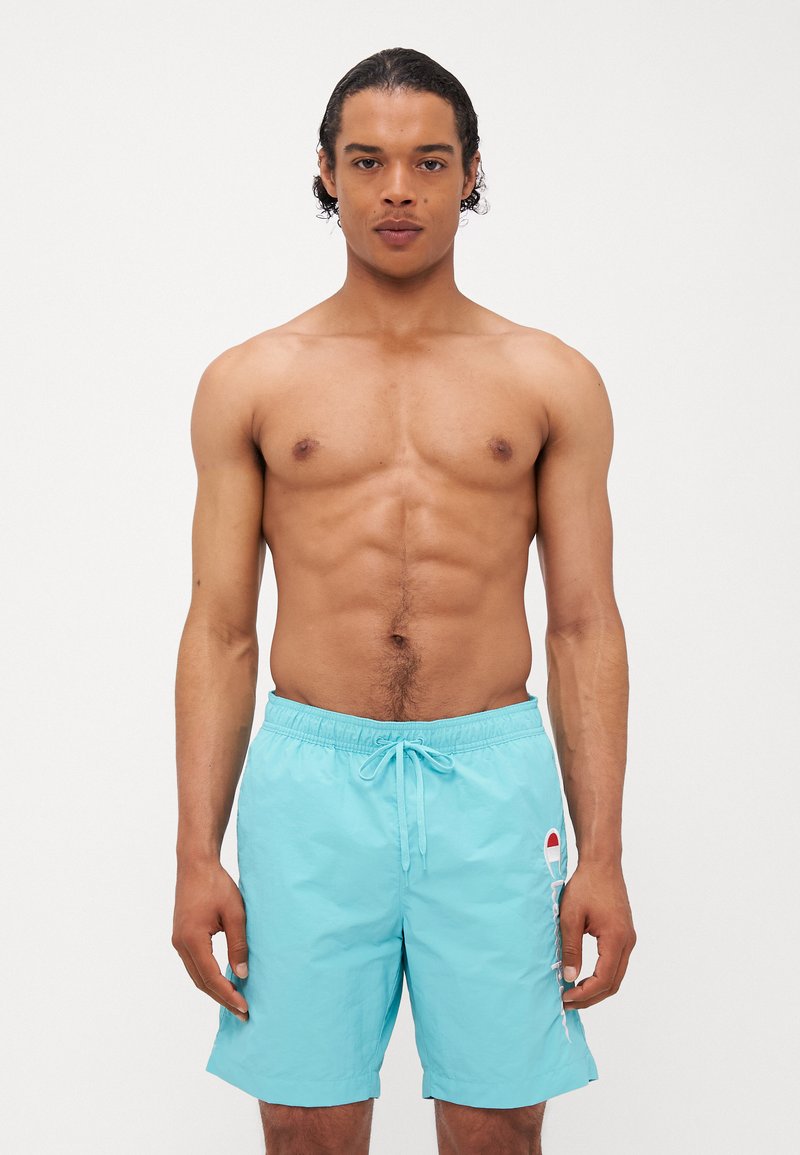 Shorts de bain bleu clair avec une taille élastique et un cordon de serrage. Présentent un détail logo sur le côté et une texture lisse et légère.