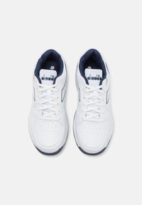 White athletic shoes featuring a smooth synthetic upper, navy accents, round toe, lightweight construction, and lace-up closure.