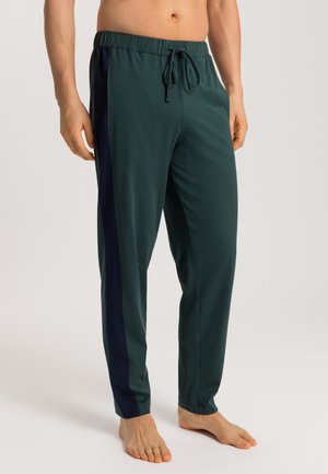 Groene sportbroek met een elastische tailleband en trekkoord, zijzakken en contrasterende navy zijstrepen. Zachte textuur en losse pasvorm.