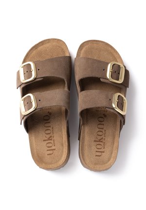 Sandali in suede marrone con due ampie fasce e grandi fibbie dorate, soletta morbida, paio affiancato su sfondo bianco.