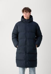 Long navy blue puffer jacket with a hood, quilted design, front zipper, side pockets, and a soft, textured finish.