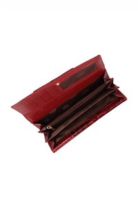 Czerwony portfel z tłoczeniem w krokodyli wzór, z wieloma przegródkami, sekcją na zamek błyskawiczny oraz przezroczystym okienkiem na dowód tożsamości. Wnętrze wyściełane tkaniną w kropki.