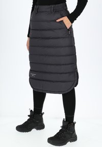 Mustat vuoratut hameet, joissa on tikattu kuviointi, joustava vyötärö, sivutaskut ja kaareva helma; yhdistetty mustiin nilkkasaappaisiin.