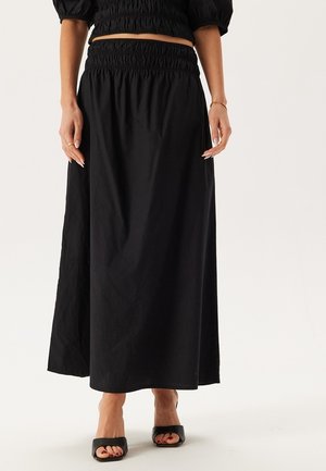 Gonna maxi nera con vita elastica, realizzata in un tessuto leggero. Il design presenta una texture liscia e una silhouette fluida.