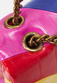 Monivärinen käsilaukku vaaleanpunaisessa, punaisessa ja sinisessä kiiltävässä materiaalissa, jossa on kultainen ketjuhihna ja metallinen brändäystarra.