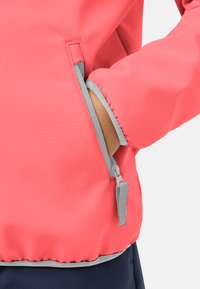 Giacca a vento corallo con accenti grigi, dotata di una tasca con zip sul lato sinistro e fondo arricciato. Tessuto liscio, materiale leggero.