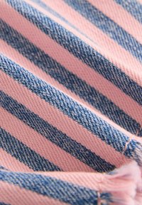 Gestreifter Stoff in pink und blau im Denim-Gewebe, mit strukturierten Mustern und deutlichen vertikalen Streifen sowie einer weichen Oberfläche.