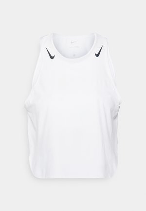 Balta bezpiedurkņu topa tērps, izgatavots no viegla auduma, ar melnām Nike logo akcentiem uz pleciem, apaļu kakla izgriezumu un brīvu piegriezumu.
