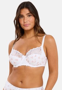 Soutien-gorge blanc avec des détails en dentelle et un motif floral. Dispose de bretelles ajustables et d'un fermoir à l'avant. Texture douce. Accents en dentelle assortis.