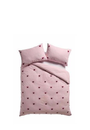 Set di biancheria da letto rosa con piccoli motivi a cuore rossi e sottili strisce bianche, che include due cuscini e una federa parzialmente piegata per il piumino.