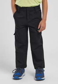 Pantalons cargo noirs avec une texture lisse, dotés de poches latérales, d'une taille ajustable et de renforts aux genoux. Portés avec des chaussures de sport bleues.
