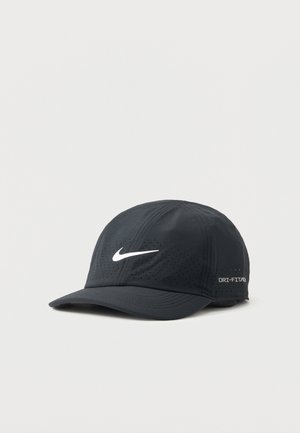 Zwarte Nike Dri-FIT sportpet met wit swoosh-logo en ventilatiegaatjes, gebogen klep en verstelbare achterriem.
