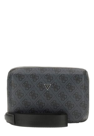 Kleine schwarze Guess-Armbanduhr mit gemustertem Logo-Print, dreieckiger Metall-Logo-Plakette und abnehmbarem Handgelenksriemen auf weißem Hintergrund.