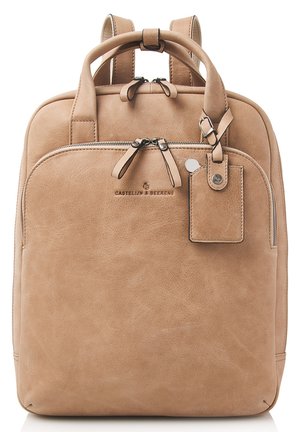 Beige leather backpack with two top handles and adjustable back straps. Features a zippered main compartment and a front pocket with a tag.