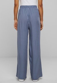 Pantalon large à rayures fines bleu et blanc avec taille élastique, fabriqué en tissu léger. Caractérisé par une texture lisse et une coupe décontractée.