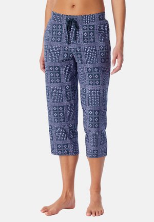 Marineblaue, kurze Hosen mit pinkem geometrischem und floralem Patchwork-Muster, Tunnelzug in der Taille, barfuß getragen an einer stehenden Person.