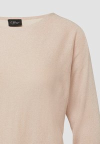 Beige long-sleeve knit sweater with subtle shimmer and crew neckline, featuring a small black label inside the collar.