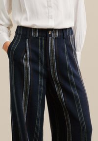 Pantalons en mélange de laine avec un tissu bleu marine à rayures verticales multicolores, poches avant et fermeture à bouton à la taille.