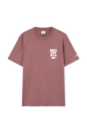 Lila T-Shirt mit kurzen Ärmeln, mit dem Schriftzug „NORTH ATL“ und kleinem Champion-Logo auf der Brust sowie einem Champion-Logo-Aufnäher am linken Ärmel.