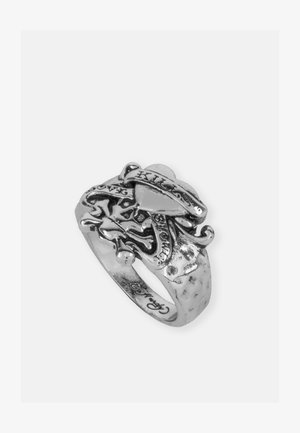 Srebrn prstan z zapletenim dizajnom lobanje in križanih kosti, z vgraviranim besedilom in teksturiranim trakom, ki prikazuje podrobnosti in obrtniško delo.