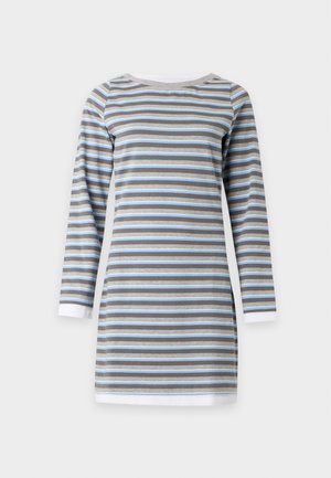 Femme portant une robe rayée bleue et grise à manches longues, des ballerines noires, et portant un grand sac blanc à l'épaule.