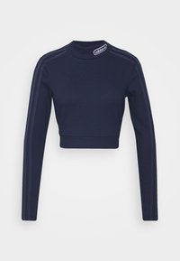 Navyblaues Bustier mit langen Ärmeln, geripptem Textur und hohem Kragen. Mit kontrastierenden dunklen Streifen entlang der Schultern und einem Logo-Patch.