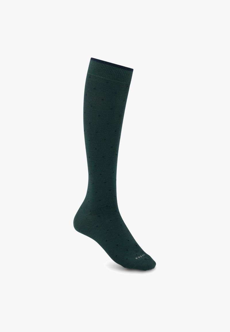 Chaussette haute vert foncé avec petits pois et bord-côte, présentée debout sur fond blanc.