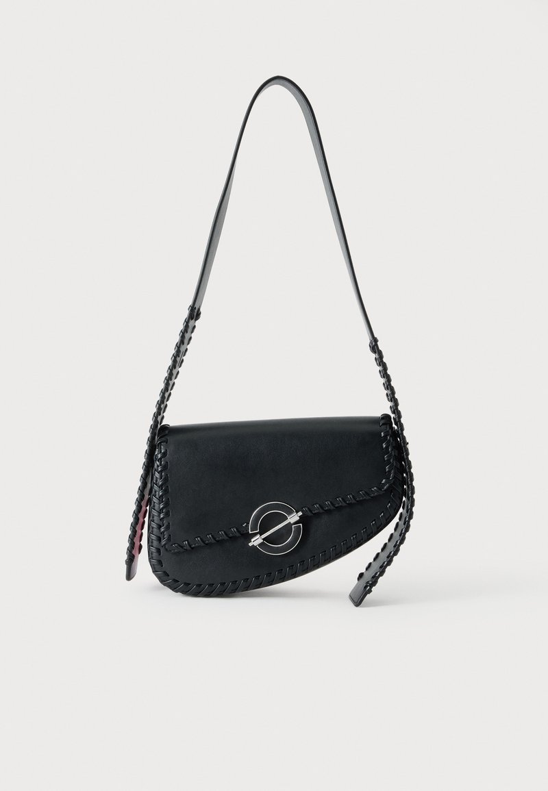 Sac à bandoulière en cuir noir avec bordure tressée, fermoir rond argenté et longue bandoulière, présenté sur un fond clair uni.
